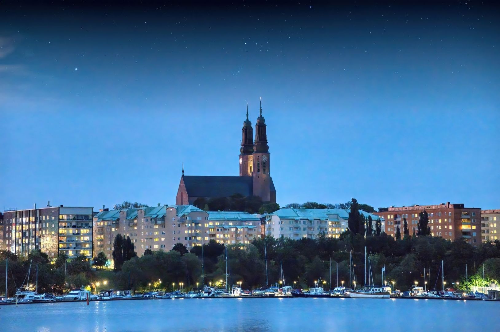 Kvällsbild av Södermalm med kyrka, bostäder och båtar vid vattnet